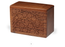 A rectangular wooden keepsake box with a rich medium-brown finish, featuring an intricate hand-carved floral pattern on the front panel, set against a plain white background.
