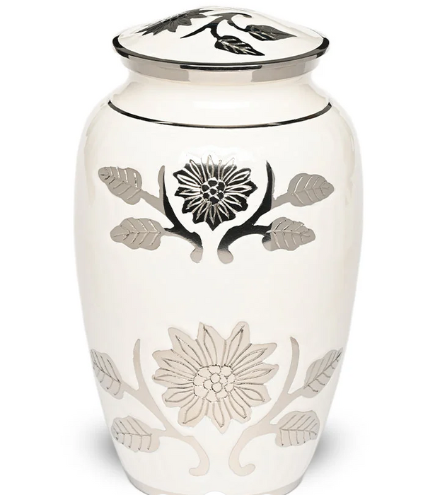 An off-white ceramic cremation urn with a matching lid, decorated with black and silver floral and leaf motifs.